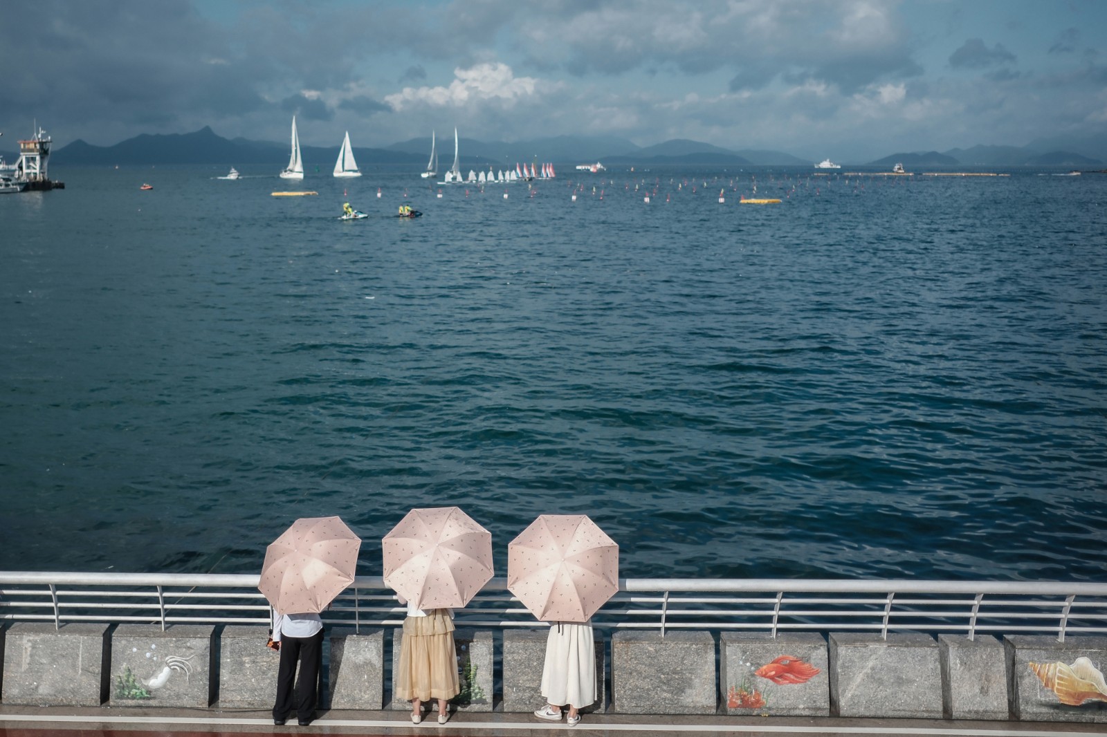 看 海-2023年6月20日，深圳南澳海边，烈日下，游客打伞看海，远处是在为端午举办龙舟赛正在进行训练的赛手们。-薛云麾.jpg